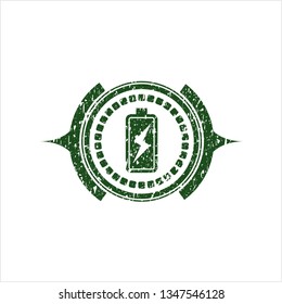 Green battery charging icon inside distressed rubber grunge seal