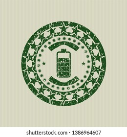Green battery icon inside rubber stamp with grunge texture