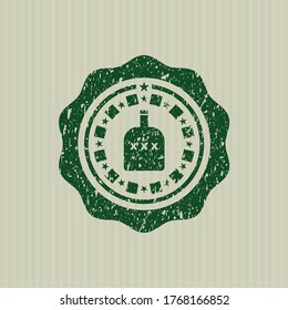 Green bottle of alcohol icon inside distressed rubber grunge texture stamp. 