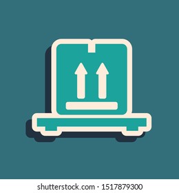 Green Cardboard boxes on pallet icon isolated on blue background. Closed carton delivery packaging box with fragile signs. Long shadow style. Vector Illustration