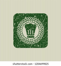Green chef hat icon inside rubber stamp with grunge texture