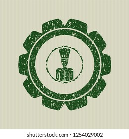 Green chef icon inside distressed rubber stamp