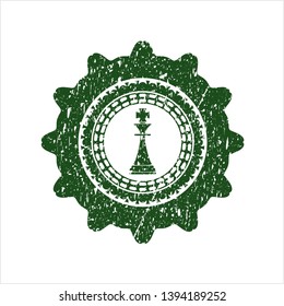 Green chess king icon inside rubber seal with grunge texture