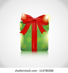 Green Christmas present width a red bow and ribbon on an silver background.