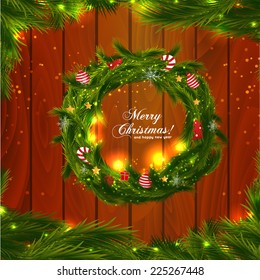 Green christmas wreath with decorations on wood background
