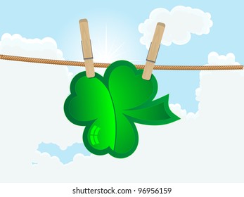 Green clover hanging on the rope against cloudy sky