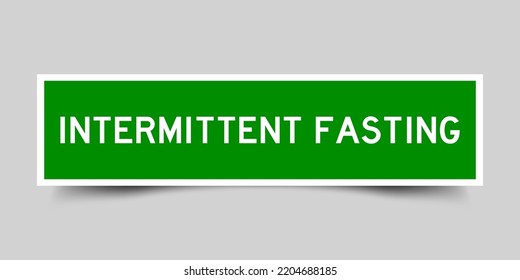 Green color square shape sticker label with word intermittent fasting on gray background
