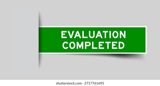 Green color square shape sticker label with word evaluation completed inserted in gray background