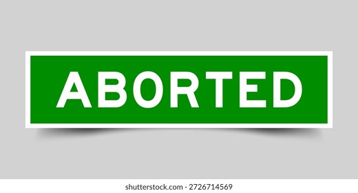 Rótulo adesivo de forma quadrada de cor verde com palavra abortada no plano de fundo cinza