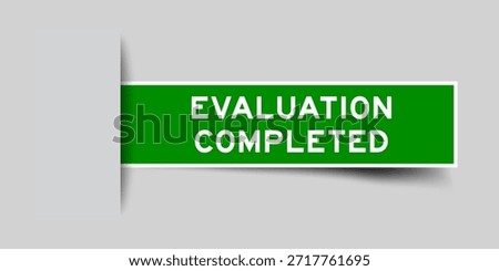 Green color square shape sticker label with word evaluation completed inserted in gray background