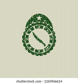 Green combat knife icon inside distressed rubber grunge texture stamp