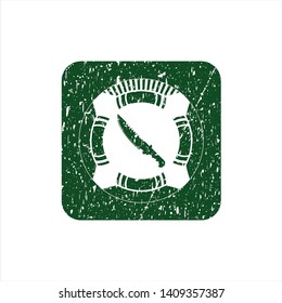 Green combat knife icon inside rubber seal with grunge texture