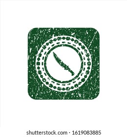 Green combat knife icon inside grunge stamp