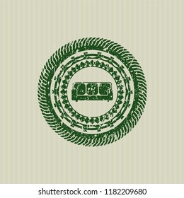 Green couch icon inside distress rubber stamp with grunge texture