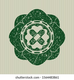 Green crossed bandage plaster icon inside grunge stamp