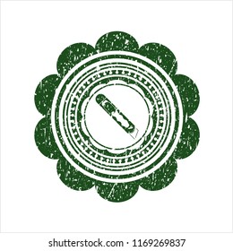 Green cutter icon inside rubber stamp with grunge texture