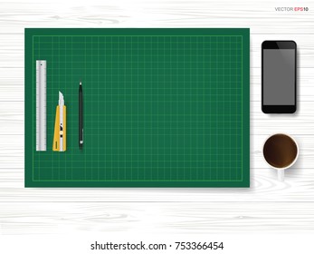 Green cutting mat with office object set with smartphone and coffee cup on white wooden background. Vector illustration.