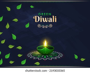 Green Diwali Concept With Illuminated Oil Lamp (Diya) Over Rangoli And Leaves Decorated On Blue Texture Background.