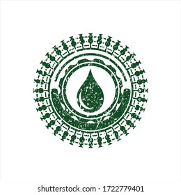 Green drop icon inside rubber grunge seal. 