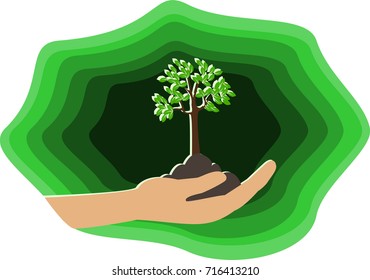 Green ecology concept. Tree in soil on hand palm