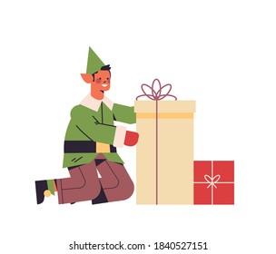green elf guy in uniform holding gift box male cartoon character santa helper happy new year merry christmas holidays celebration concept full length vector illustration