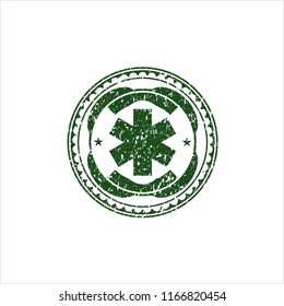 Green emergency cross icon inside distressed rubber seal