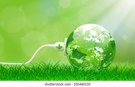 Green energy concept with Planet Earth and electric plug on lush grass