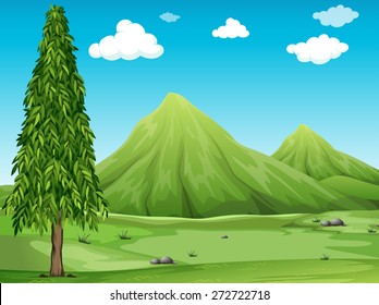 Green field with a tree and mountains
