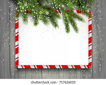 Grüne Tannenbaum Äste auf Holzhintergrund. Natürliche Gestaltungselemente. Winterschnee-Hintergrund mit Platz für Text.