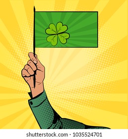 Green flag with clover in hand. St.Patrick 's Day