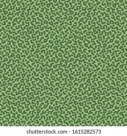 Green flecked texture. Mottled background. Wallpaper or tile pattern.