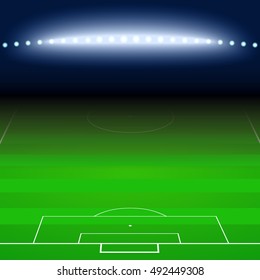 Green football, soccer field with white markings and a light goes on in the shadows. Sports background