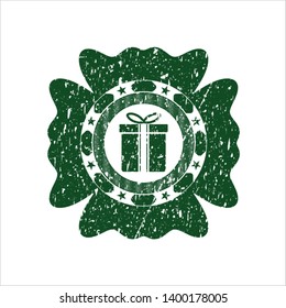 Green gift box icon inside rubber stamp with grunge texture
