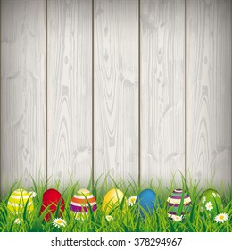 Green grass with colored easter eggs on the wooden background. Eps 10 vector file.