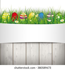 Green grass with colored easter eggs on the wooden background. Eps 10 vector file.