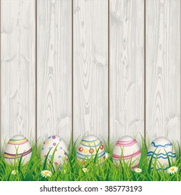 Green grass with colored easter eggs on the wooden background. Eps 10 vector file.