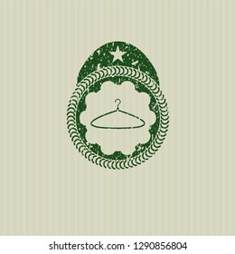 Green hanger icon inside distressed rubber grunge seal
