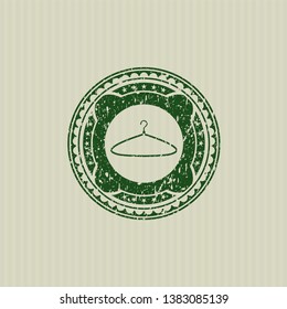 Green hanger icon inside distressed grunge seal