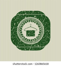 Green hanger with towel icon inside distress grunge style stamp