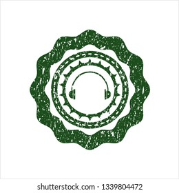 Green headphones icon inside distressed rubber grunge stamp