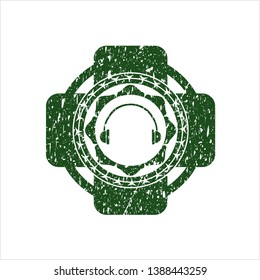 Green headphones icon inside distressed rubber seal