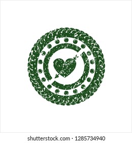 Green heart with arrow icon inside rubber texture