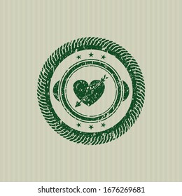 Green heart with arrow icon inside distressed with rubber seal texture