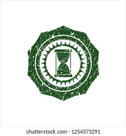 Green hourglass icon inside grunge style stamp