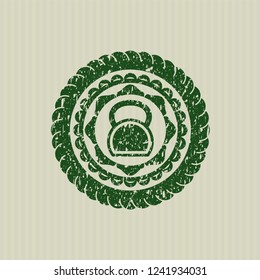 Green kettlebell icon inside rubber stamp
