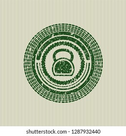 Green kettlebell icon inside rubber seal with grunge texture