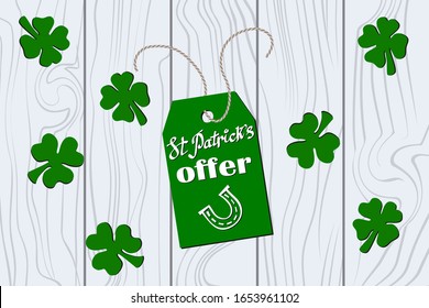 Green Label with handwritten lettering "St Patrick's Offer" and horseshoe on a rustic rope On the wooden table background. Vector flat illustration St Patrick's day sales & offer tag. 