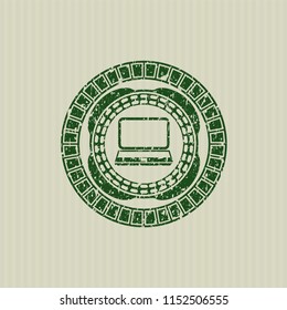 Green laptop icon inside rubber stamp with grunge texture