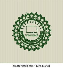Green laptop icon inside rubber seal with grunge texture