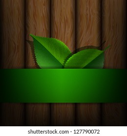 Green leaves on a background of wood texture, ecological concept